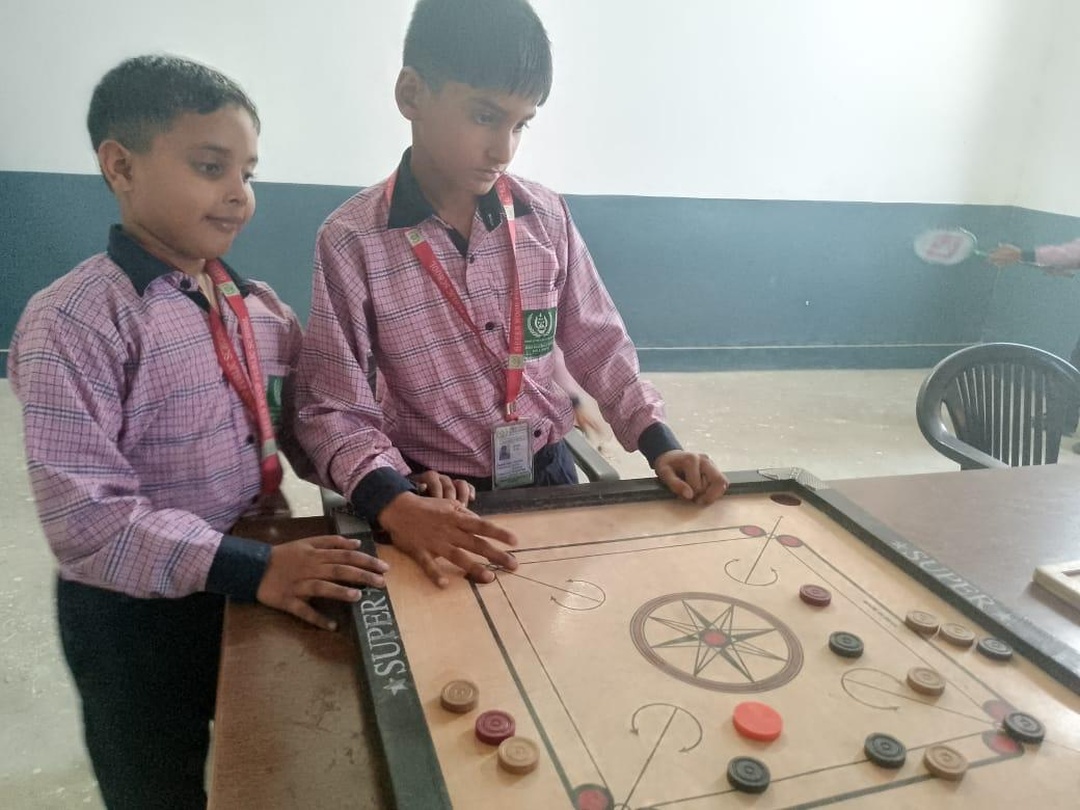 Students in school uniform concentrating on a carrom match